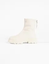 Botas cortas color crema, de cuero vegano, con suela track y cierre trasero con cremallera.