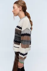 Sweater de lana merino color crudo con dibujos geométricos y detalles en lentejuelas.