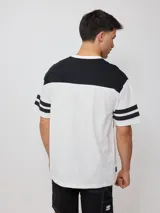 Remera blanca de hombre con corte negro en la parte superior del pecho y mangas cortas con tres rayas horizontales negras. Estampado frontal con el logo de Rusty en negro y la palabra 'Culture' en rojo.