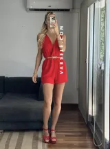 Mono corto negro con escote en V cruzado, sin mangas y con cinturón dorado.