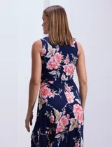 Vestido largo de seda fría con estampado floral en tonos rosados y blancos sobre fondo azul marino. Presenta cuello redondo con abertura en forma de ojal y aplique metálico.