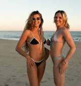 Top de bikini con forma de triángulo ajustable, breteles regulables y lazos frontales. Diseño color block con una copa celeste brillante y otra lila brillante, con ribetes turquesa.