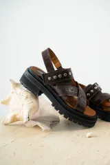 Sandalias negras de charol con tiras cruzadas y plataforma track.