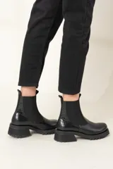 Botas Chelsea de cuero vacuno color negro, con elástico lateral, caña corta y suela track.