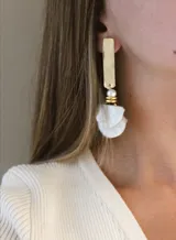 Aros colgantes con base dorada, perla blanca y colgante de conchas blancas.