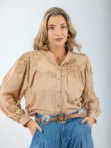 Camisa color crema de broderie, corte holgado, con cuello mao y mangas largas abullonadas con bordados florales.