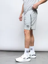 Short deportivo gris de poliéster y elastano, con perforaciones y detalles de cinta con logo Umbro en los laterales.