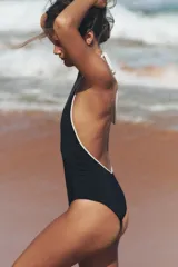 Bañador negro con escote pronunciado en V, cuello halter con lazo blanco y forro interior.