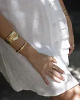 Brazalete rígido plateado con textura irregular.