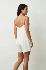 Mono corto color crudo, con breteles finos, escote en V y cierre frontal con botones.