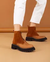 Botas cortas color beige con cierre frontal de cremallera, suela track negra y tirador trasero.