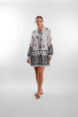 Vestido de corte fluido con estampado en blanco y negro, mangas largas y detalle de bordado.