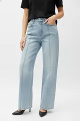 Pantalón de jean de tiro alto y calce holgado, color celeste claro lavado. Se caracteriza por tener costuras verticales marcadas que recorren el frente de ambas piernas.