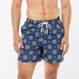 Short de baño azul con estampado de mosaicos blancos y azules.