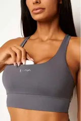 Top deportivo gris con diseño nadador, confeccionado en poliamida de alta performance. Cuenta con bolsillo trasero, bolsillo interno en el forro frontal y detalles reflectivos.