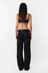 Pantalón negro de corte recto y tiro medio, con recortes en las piernas con detalle de vivo. Cintura con presillas y cinto correa con broche plástico incluido.