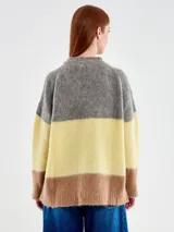 Buzo de punto con diseño de rayas horizontales anchas en colores gris, amarillo y marrón. Presenta una silueta amplia y relajada, cuello a la base y mangas largas. Confeccionado en una mezcla de alpaca, poliamida y lana.
