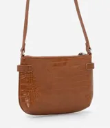 Bolso bandolera pequeño color marrón con textura de piel de cocodrilo, correa fina ajustable, cierre de cremallera y hebillas laterales decorativas.