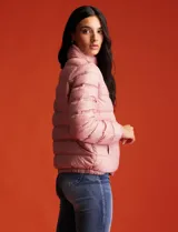Campera puffer reversible Michael Kors color rosa con estampado de logos MK en un lado y liso en el otro. Tiene cierre central metálico, bolsillos delanteros y avíos metálicos con logo. Incluye bolsa autoportante.