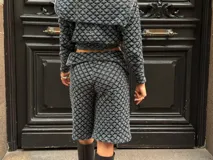 Campera corta de crochet de hilo celeste y negro, con cierre frontal y forro interior.