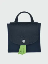 Mochila Longchamp modelo Le Pliage Green, color azul marino, con solapa de cuero texturizado y logo de la marca en relieve.