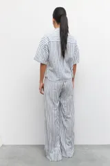 Pantalón largo azul con rayas verticales blancas, de corte amplio, con cintura elastizada y cordón ajustable.