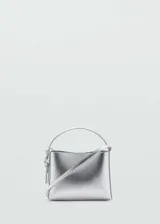Bolso mini tipo bucket plateado, con asa de mano rígida y correa bandolera fina ajustable.