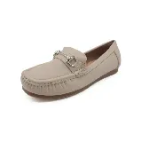 Mocasín de cuero color beige con detalle de hebilla metálica plateada.
