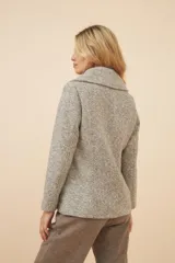 Chaquetón color crema con doble solapa, abrochadura doble, bolsillos delanteros y forro al tono.