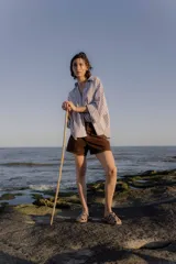 Sandalias tipo mule de cuero color marrón chocolate, con diseño de tiras anchas cruzadas y suela plana.