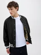 Campera bomber negra con cuello tipo baseball y puños de canalé. Cierre frontal con botones a presión y bolsillos laterales.