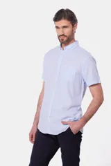Camisa celeste de lino y algodón, de manga corta, con cuello abotonado y bolsillo en el pecho.