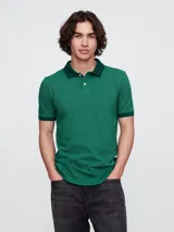 Remera polo verde con cuello y mangas en verde oscuro, con logo bordado en el pecho.