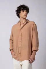 Camisa blanca de lino con cuello clásico, manga larga con puños abotonados y corte holgado. 