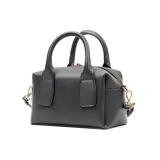 Cartera chica de símil cuero graneado color negro, con doble asa corta y correa larga regulable. Tiene cierre superior, un bolsillo interno con cierre y otro abierto. El interior es de tela de algodón y poliéster.