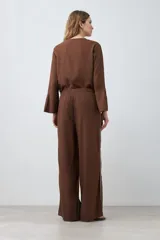 Pantalón de lino color chocolate, de corte palazzo, con cintura elastizada y vivo blanco en los laterales.