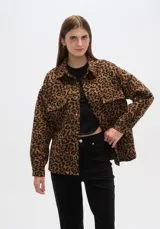 Chaqueta tipo camisa de corte holgado con estampado animal print, cuello camisero, cierre frontal con botones y bolsillos de parche en el pecho.