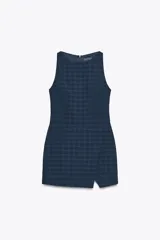Mono corto azul con estampado de cuadros, cuello redondo, sin mangas y abertura en el bajo delantero. Cierre trasero con cremallera.