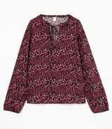 Blusa ancha de viscosa con cuello mao y mangas largas con puños elásticos. Estampado de flores en tonos borgoña y negro.