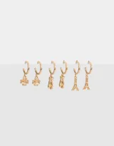 Set de tres pares de aros tipo argolla dorados con dijes colgantes: trébol de cuatro hojas, zapatillas de ballet y la Torre Eiffel.