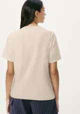 Remera color marrón claro, de corte recto, con cuello redondo y mangas cortas.