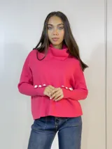 Sweater fucsia de punto con cuello alto y botones decorativos en los puños.
