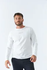 Remera blanca de manga larga con cuello redondo y logo estampado en el pecho.