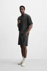 Bermuda negra de corte relaxed fit, con cintura elástica ajustable con cordón, bolsillos frontales y bolsillo trasero de parche.