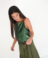 Top dorado de lentejuelas con breteles finos y ribete de cuero marrón.