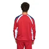 Buzo deportivo Umbro del Club Nacional de Football, color rojo con mangas azul marino y detalles blancos en hombros y laterales. Presenta el logo de Umbro bordado en el pecho y el escudo del club en el lado derecho.