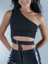 Top corto negro con textura brillante, de corte asimétrico con un solo hombro descubierto y un detalle de tiras cruzadas con hebilla metálica en la cintura.