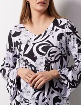 Blusa de seda fría estampada en blanco y negro, marca Ruby Rd. Tiene escote en V y mangas 3/4 amplias.