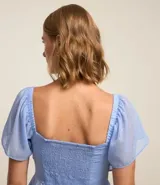 Blusa peplum de chiffon celeste con lunares blancos, escote cuadrado con lazo, mangas cortas godê, lastex en la espalda y pedrería de strass aplicada.