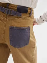 Pantalón de denim color marrón claro, de tiro alto, corte amplio y pinzas en la cintura.